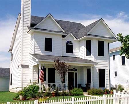 Two-story house plan exterior with white siding, prominent chimney, covered front porch, and gabled rooflines.