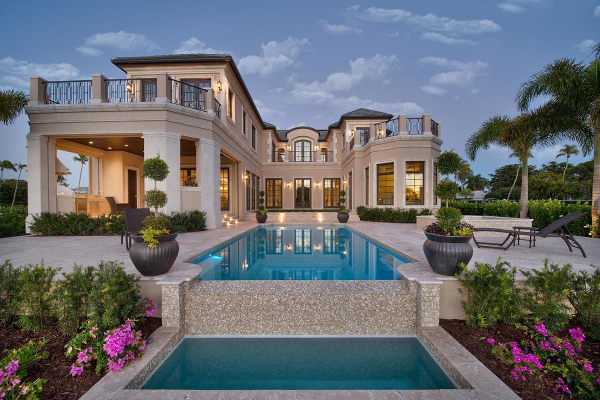 House plan exterior: Multi-story estate with central courtyard pool, covered loggia, and second-story balconies with ornate railings.