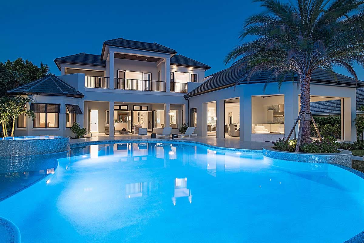 Modern house plan exterior, two stories, with balcony, expansive windows, and covered outdoor living space.