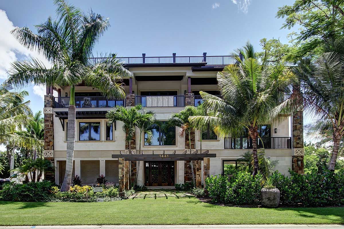 House plan exterior: Three-story modern residence with multiple balconies, stone accents, and prominent entryway.