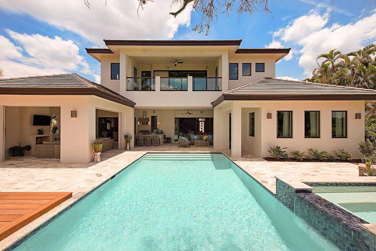 Modern house plan exterior with two stories, multiple gables, covered balcony, open patio, and attached garage.