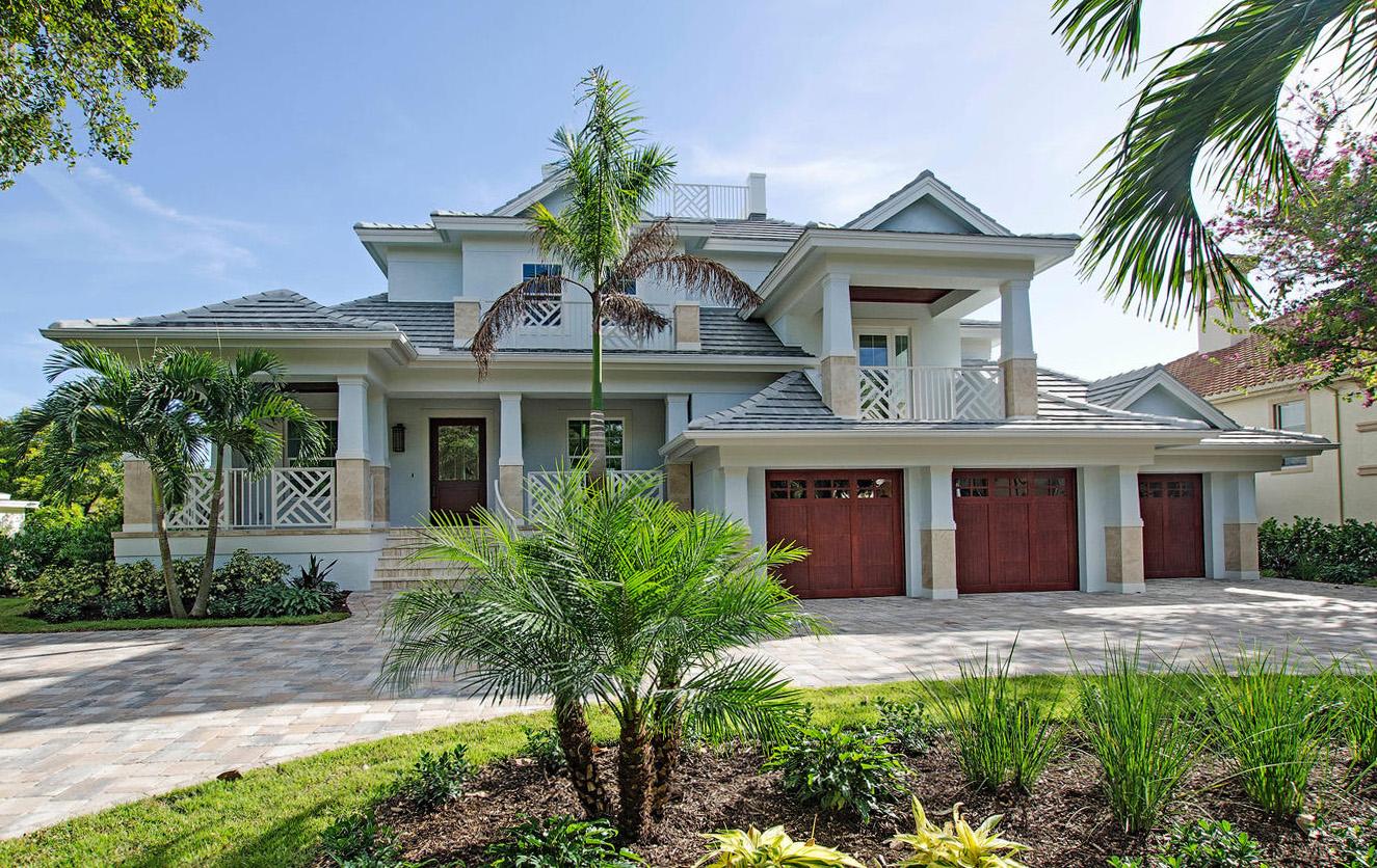 House plan exterior of a two-story home with a tile roof, multiple gables, a porte-cochère, and a four-car garage.