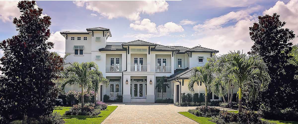 House plan exterior: Two-story modern home with balconies, a central covered entry, multiple gables, and a detached garage.