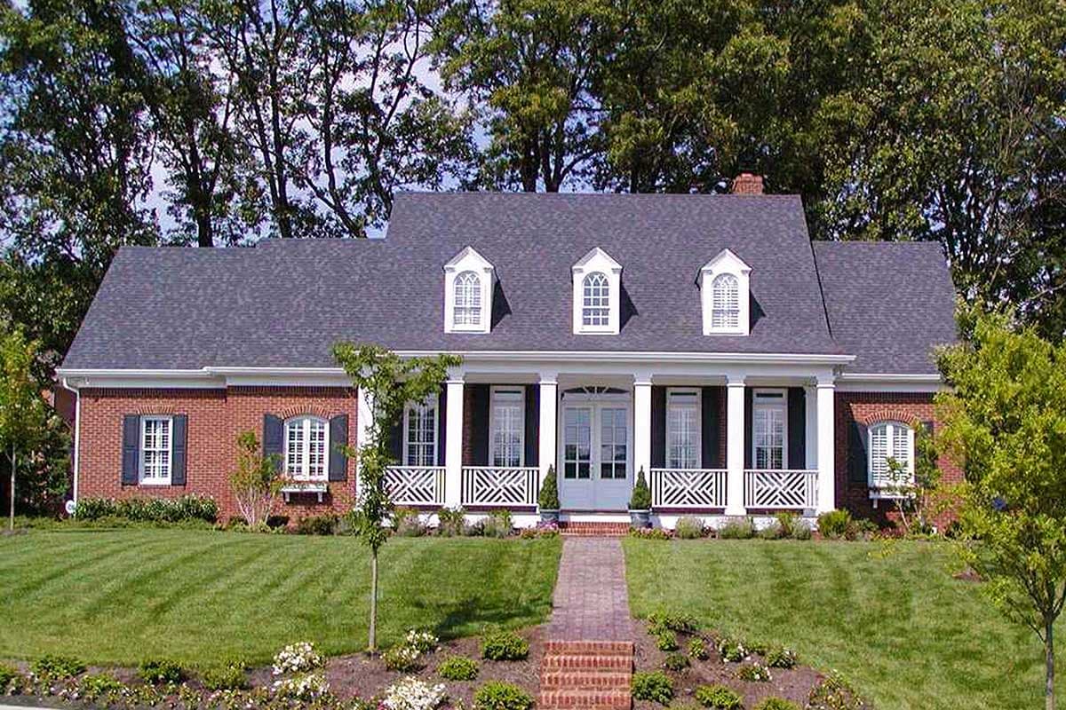 House plan exterior: Brick ranch with central portico, white columns, white railings, and three dormer windows.