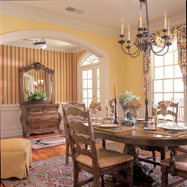 Formal dining room with a large oval table set for dinner, flanked by chairs, and an ornate dresser with mirror.