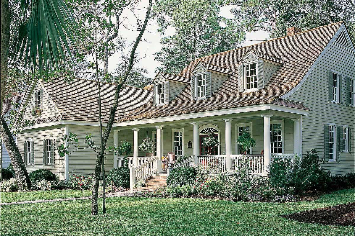 House plan exterior: Two-story home with a wraparound porch, dormer windows, and multi-level rooflines.