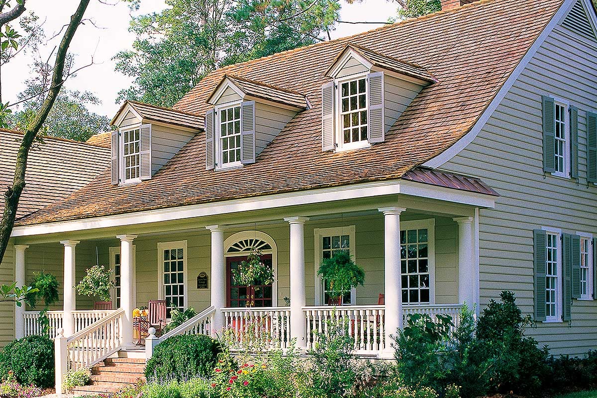 House plan exterior featuring a wraparound porch with columns, three dormer windows, and a gambrel roof.