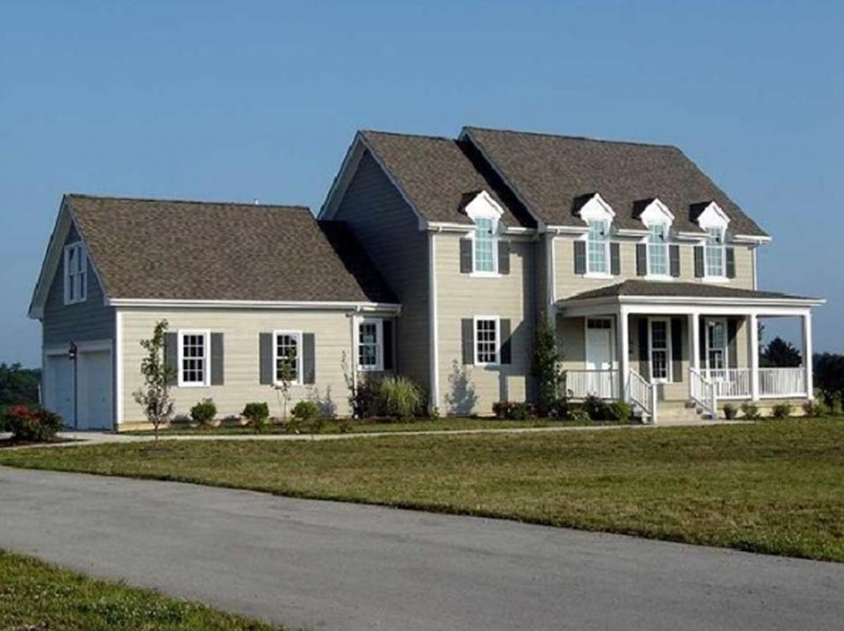 House plan exterior: Two-story dwelling with attached garage, gabled dormers, and a covered front porch with white railings.