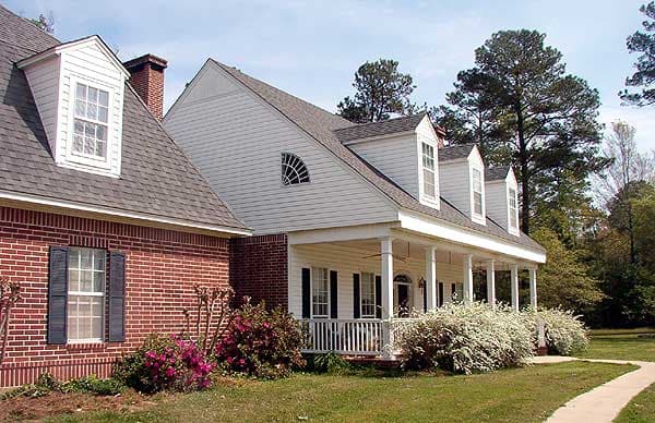 House plan exterior showing brick and siding, two stories, full-length front porch with columns, and multiple dormers.