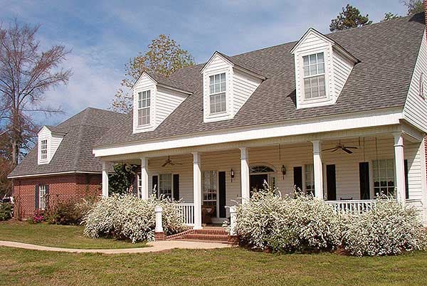 House plan exterior: Traditional style two-story with wide covered porch, dormer windows, and gabled rooflines.
