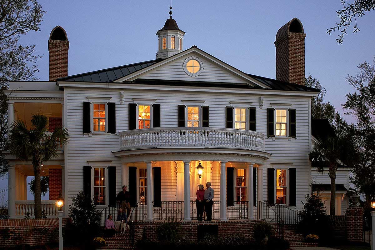 House plan exterior: Two-story historic Southern home with wrap-around porch, central balcony, cupola, and brick chimneys.