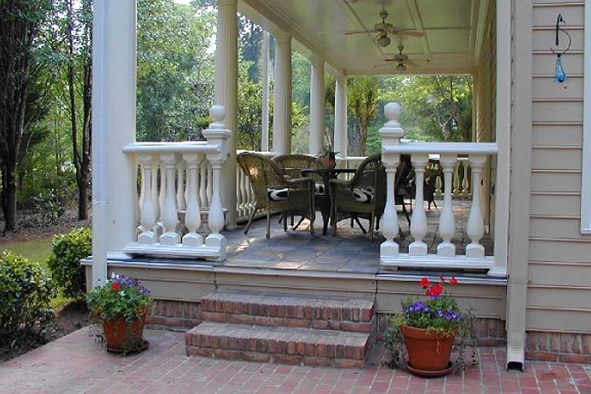 House plan exterior featuring a wrap-around porch with white balusters, columns, ceiling fans, and brick steps.