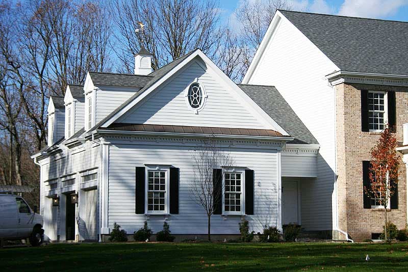 Exterior house plan with gabled dormers, cupola, circular window, and attached garage.