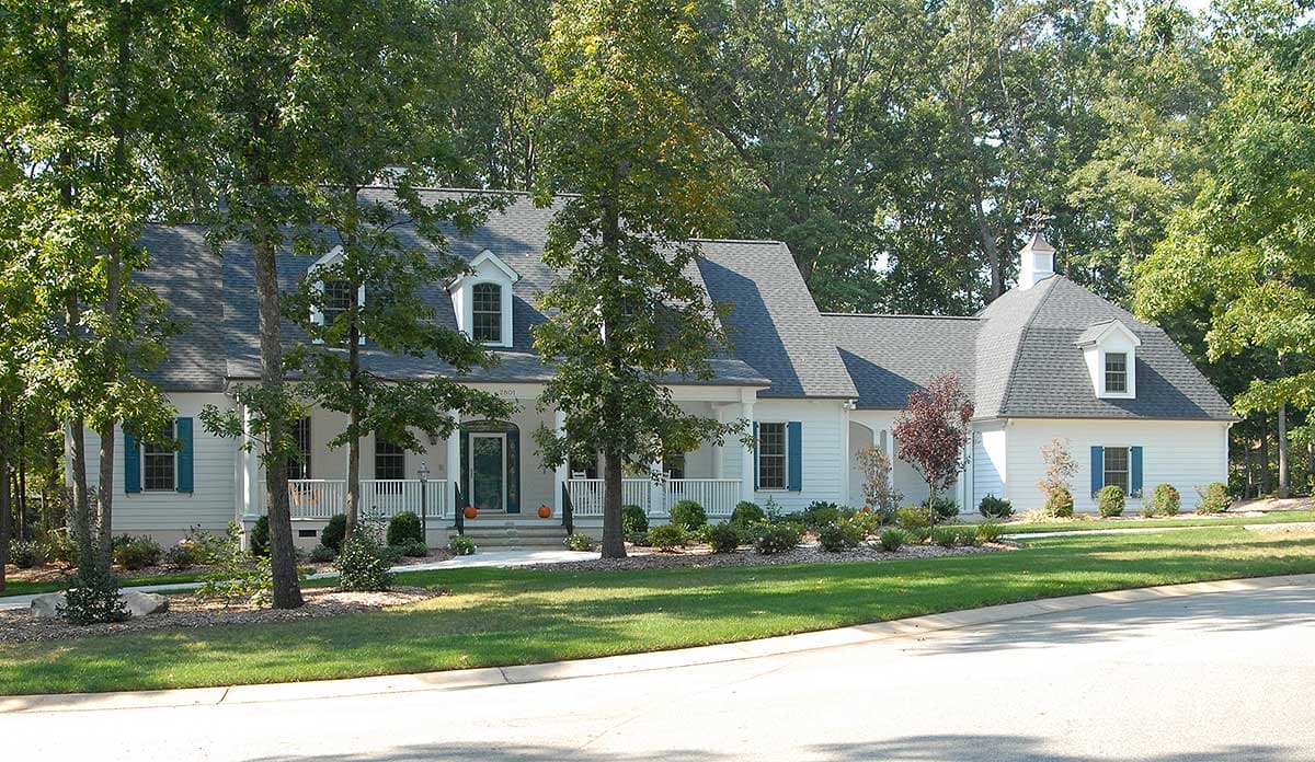 House plan exterior: Ranch style, 1.5 stories, wraparound porch, dormers, gables, and mansard roof.