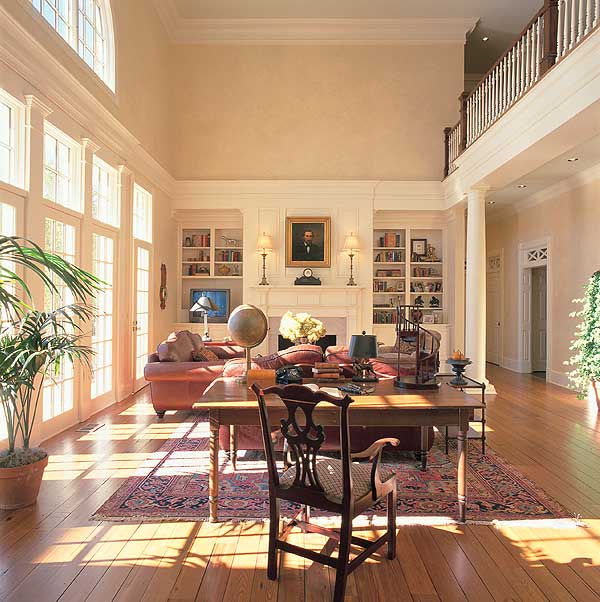 Interior rendering of a two-story great room with fireplace, built-in bookshelves, and a second-floor balcony overlook.