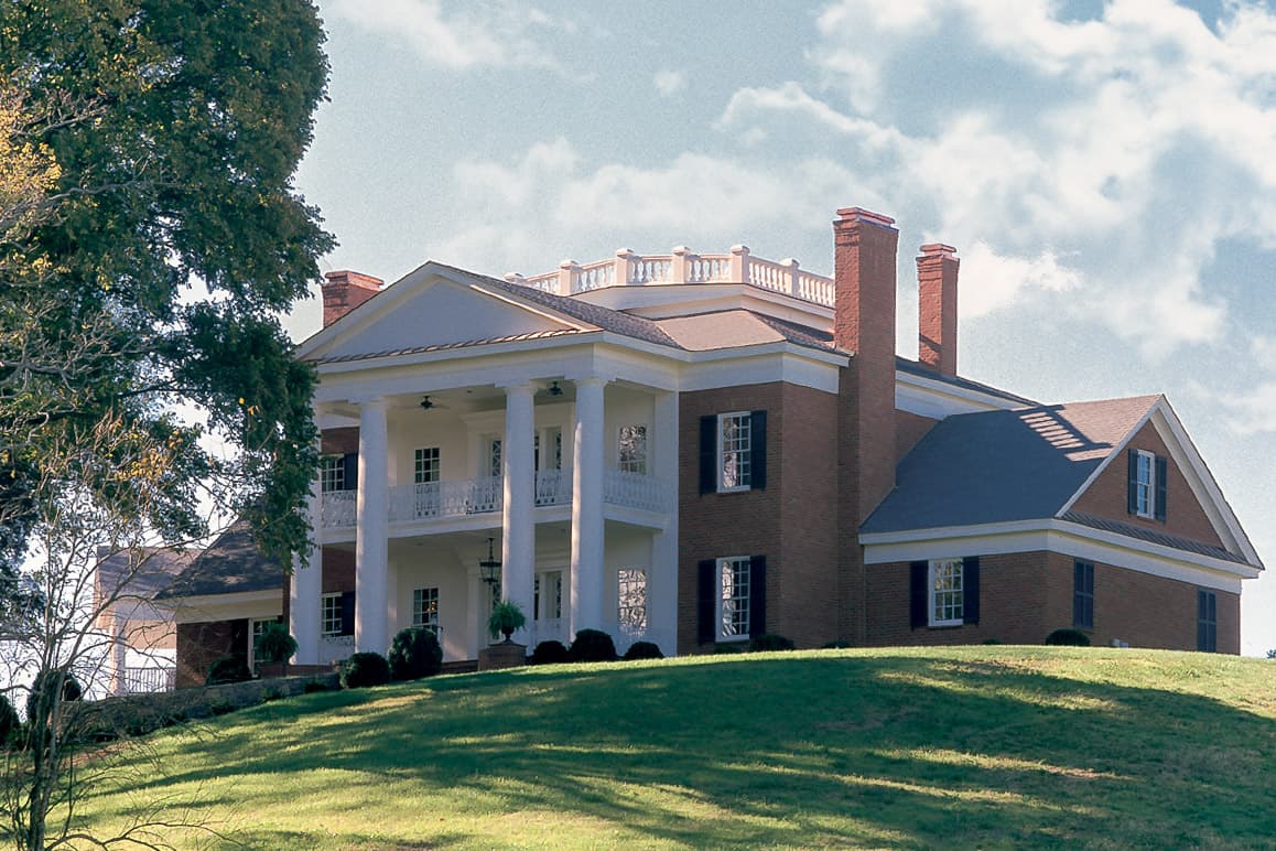 House plan exterior of a two-story brick home with a portico, balconies, and classical columns.