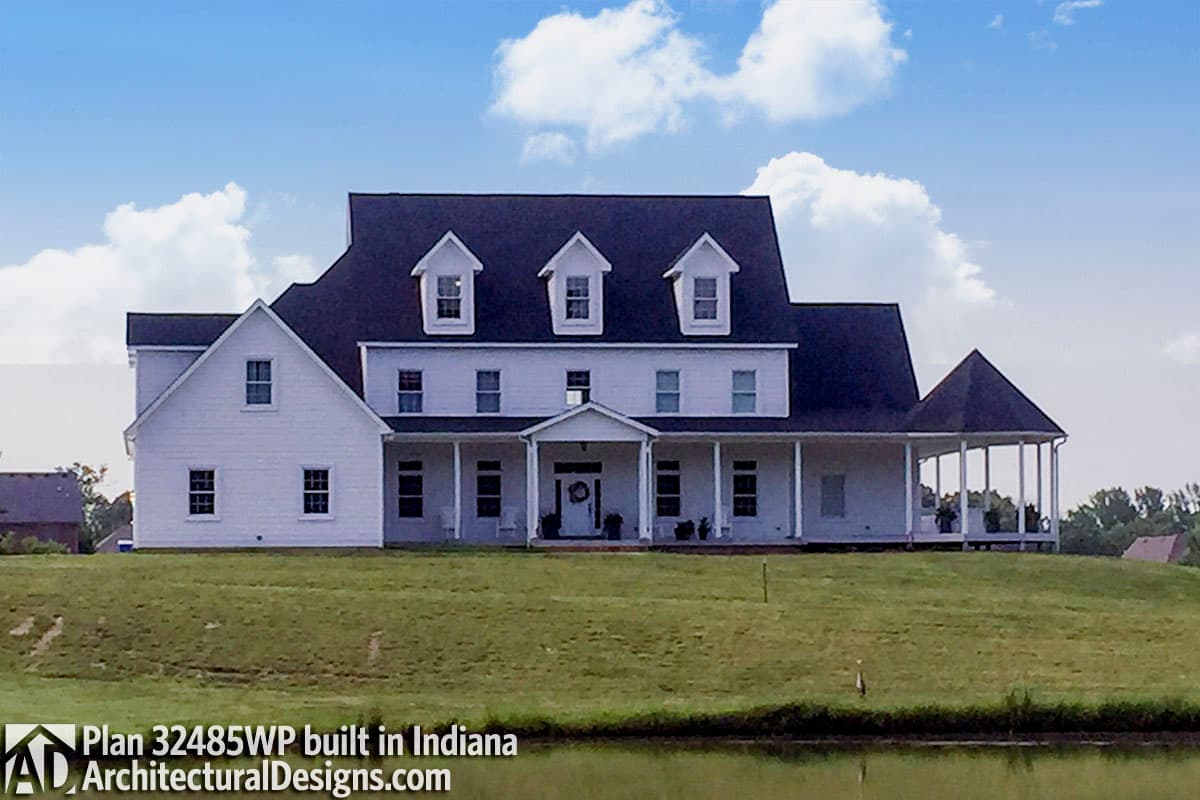 House plan exterior featuring a wrap-around porch, multiple gables, and dormer windows on a two-story structure.