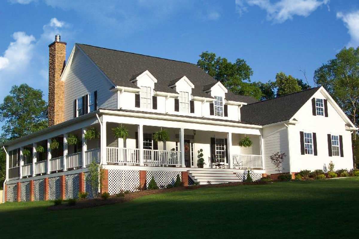 House plan exterior: two-story white farmhouse with wraparound porch, gables, and brick chimney.