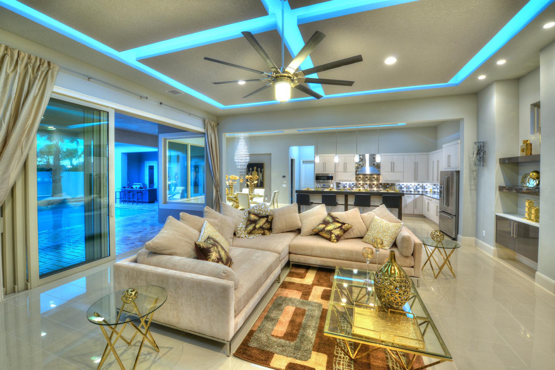 Open concept living area with sectional sofa, modern kitchen with island, and recessed ceiling lighting.