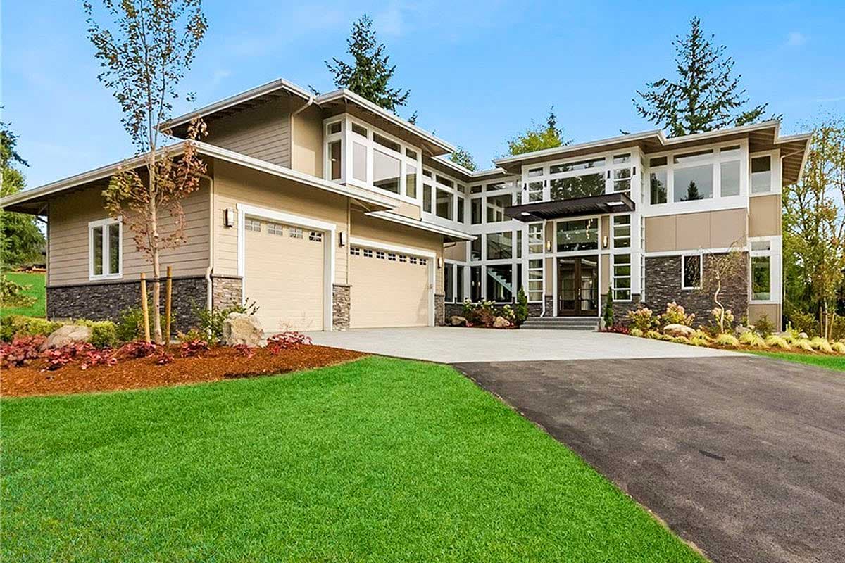 House plan exterior with modern design. Features include a two-car garage, multiple stories, and an extensive glass facade with a flat roof.