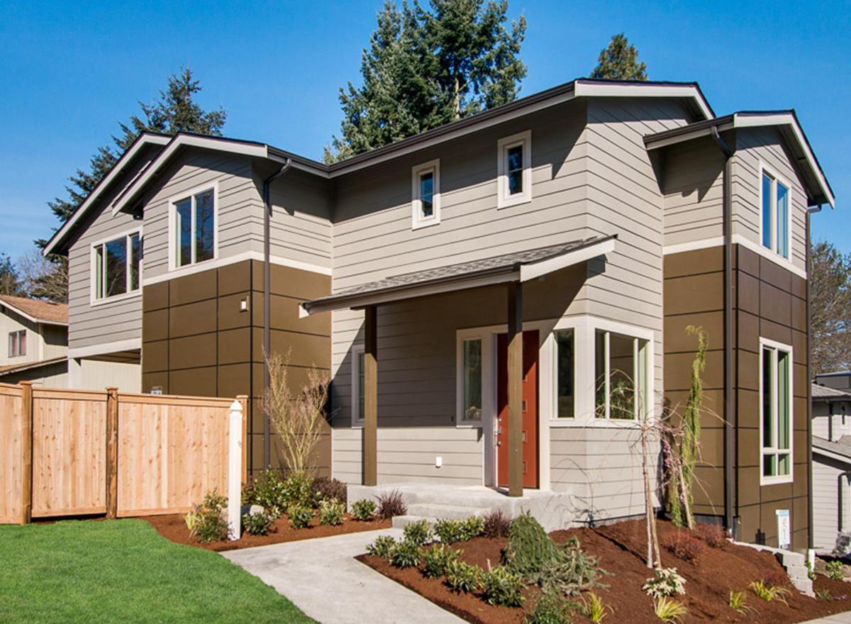 House plan exterior: two-story modern home with dual-tone siding, covered entry porch, and gable rooflines.