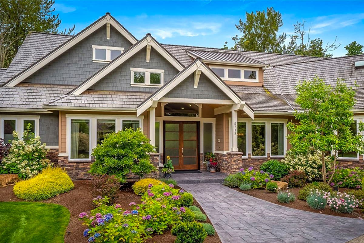 Craftsman house plan exterior with a covered entry, dual gables, stone accents, and shingle siding.