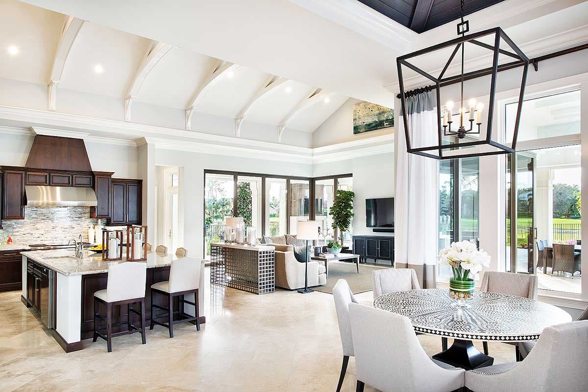 Spacious modern luxury living room with a dining area, kitchen, and open floor plan. Features high ceilings, large windows, and elegant decor.