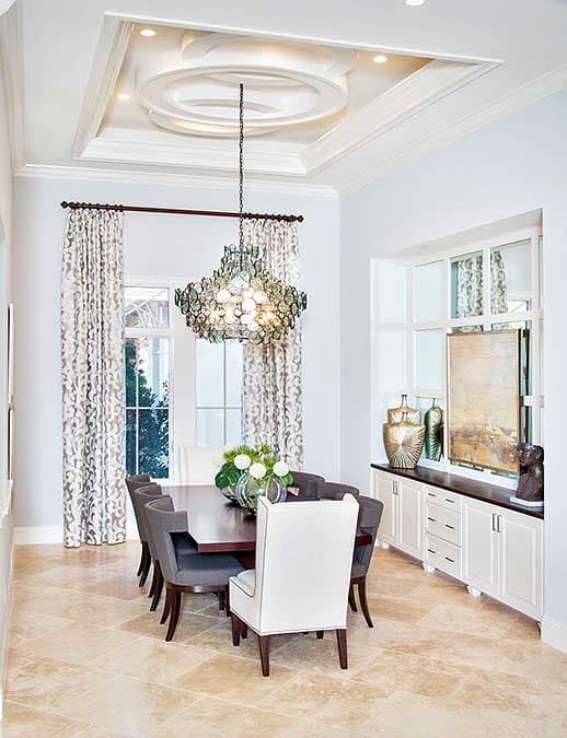 Elegant dining room with a crystal chandelier, a long dining table and matching chairs.