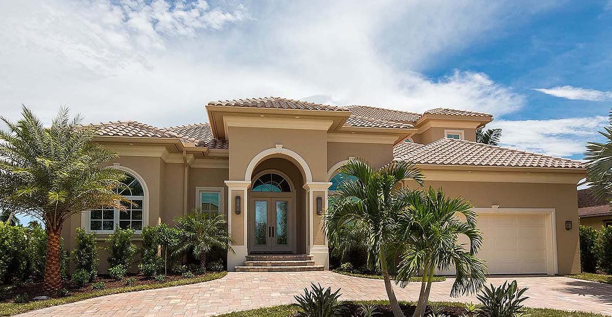 House plan exterior. One-story Mediterranean style. Features include barrel tile roof, arched entry, and portico with columns. Garage is on the side.