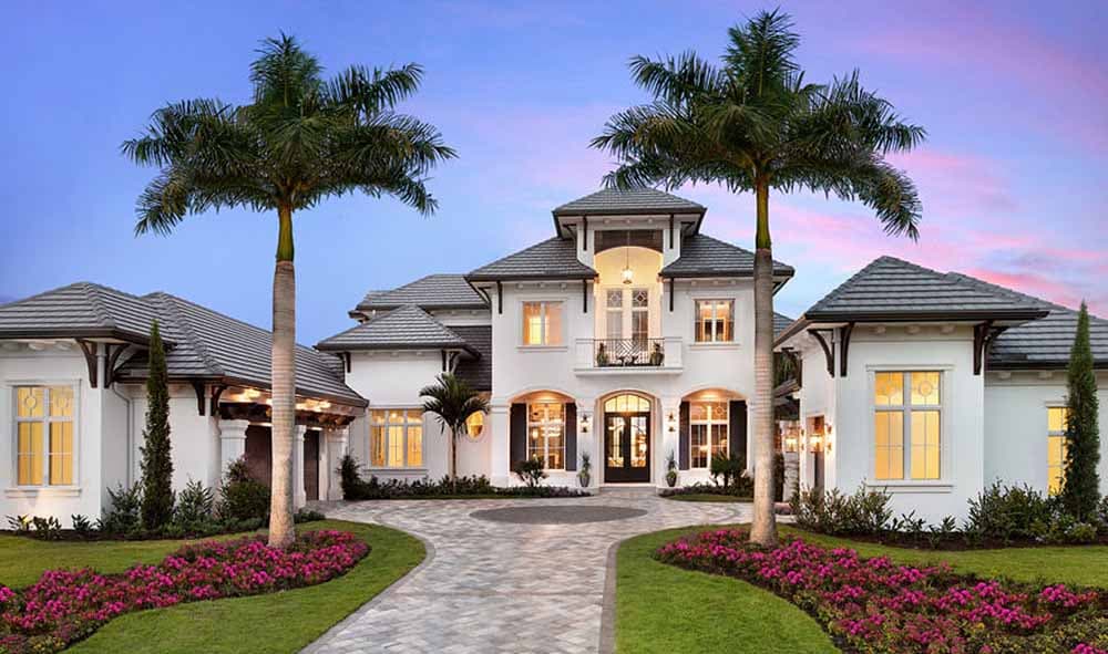 House plan exterior: Two-story Mediterranean style with arched entryway, balcony, tile roof, and two garage bays.