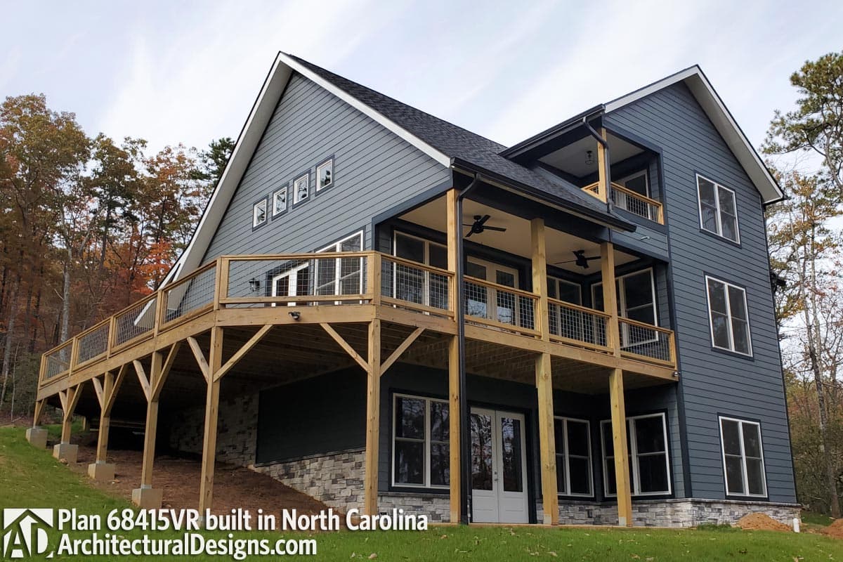 House plan exterior with a modern farmhouse style, multiple levels, large deck with cable railing, and gabled rooflines.