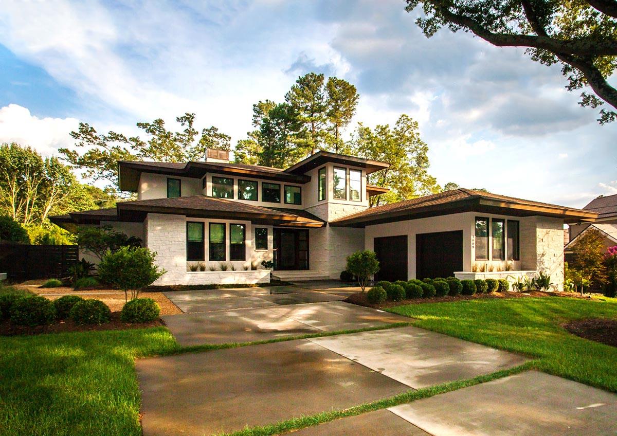 Modern house plan exterior with white stone, flat roofs, multiple gables, and a three-car garage.