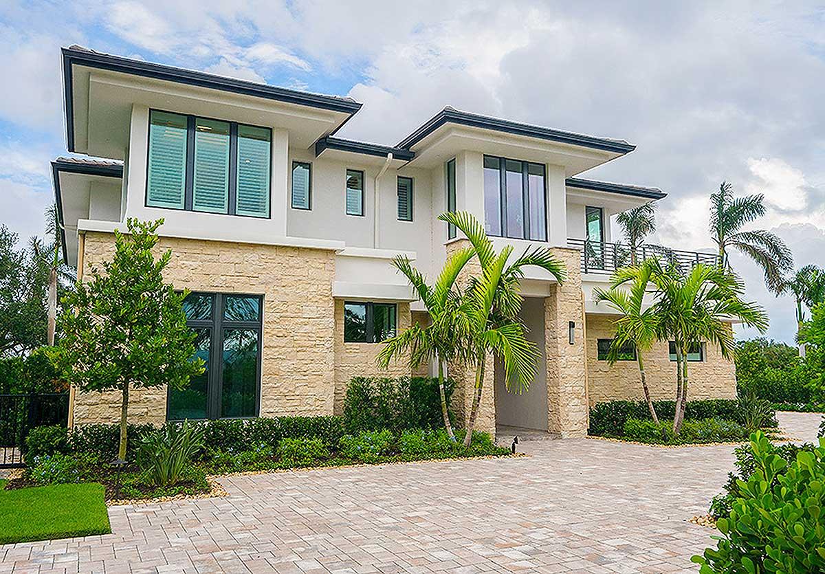 Modern house plan exterior with two stories, layered rooflines, stone accents, and large windows.