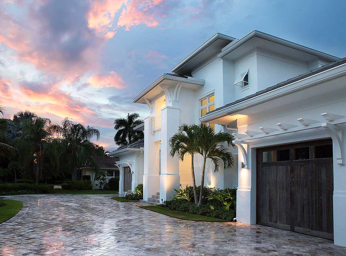 House plan exterior: Modern style, two-story, white stucco, with flat rooflines, large wooden garage door, and driveway.