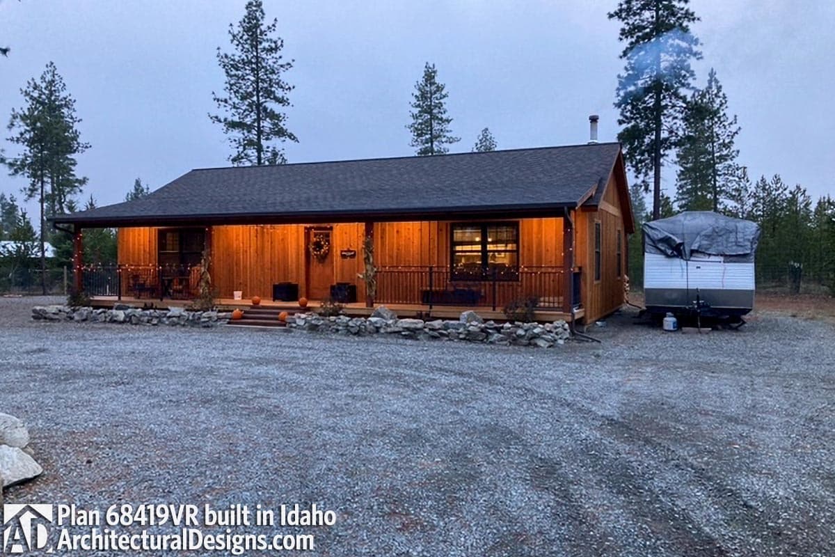 Ranch house plan exterior with a wide covered porch, wood siding, and a gabled roof.