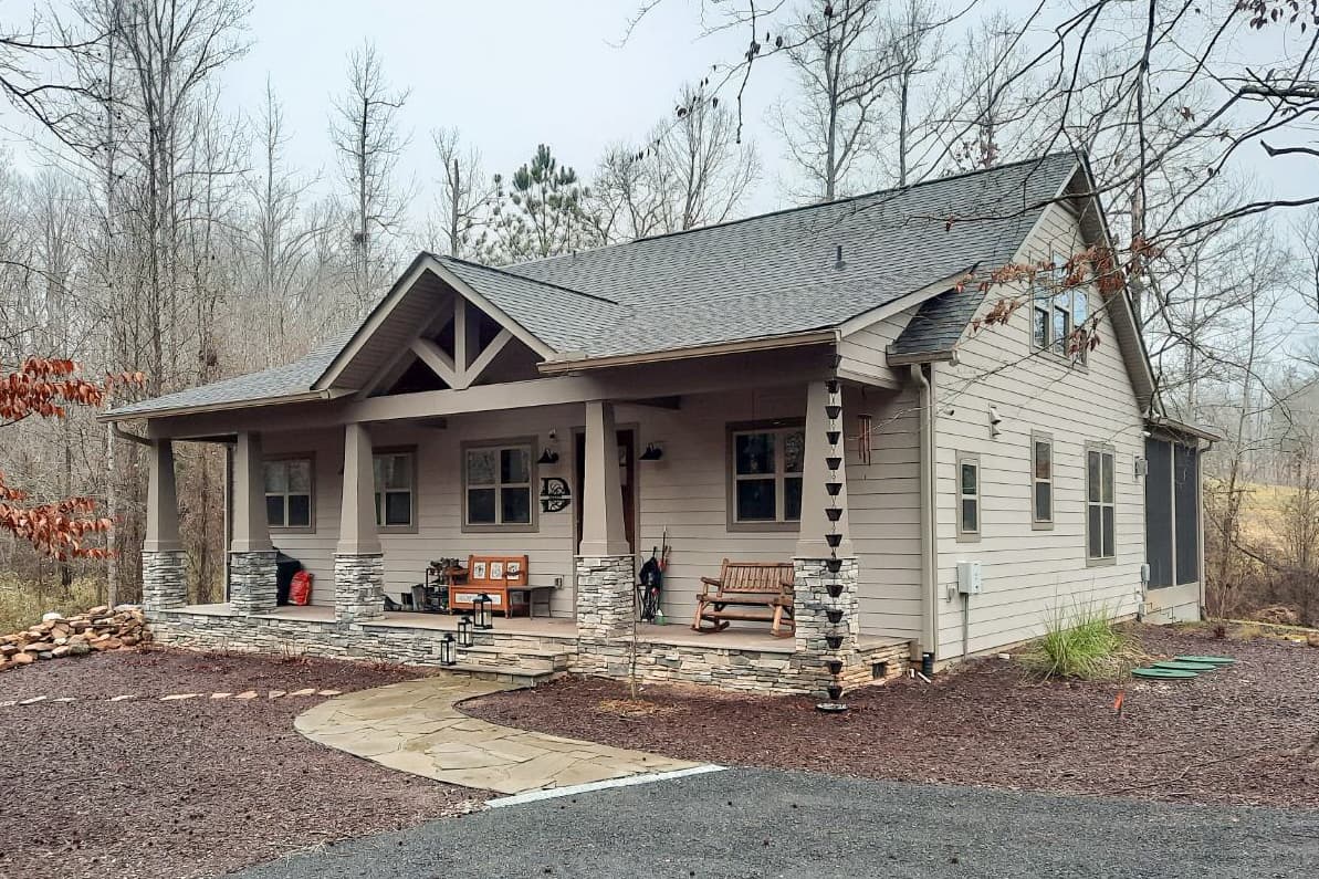 House plan exterior. Craftsman style with a gabled roof, stone-clad porch columns, and a front porch. Features include a side-entry screened porch.