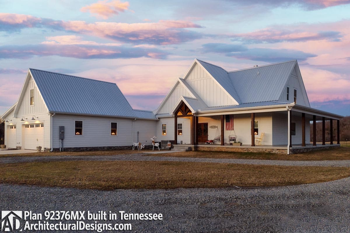 Modern Farmhouse plan exterior with metal roof, three-car garage, and wrap-around porch.
