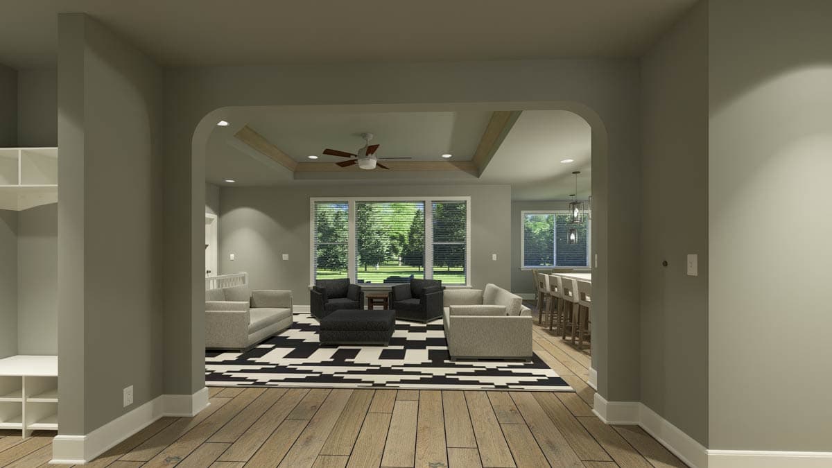 A modern living room interior. Through an archway, a seating area with a patterned rug, sofas, and armchairs is visible, alongside large windows.