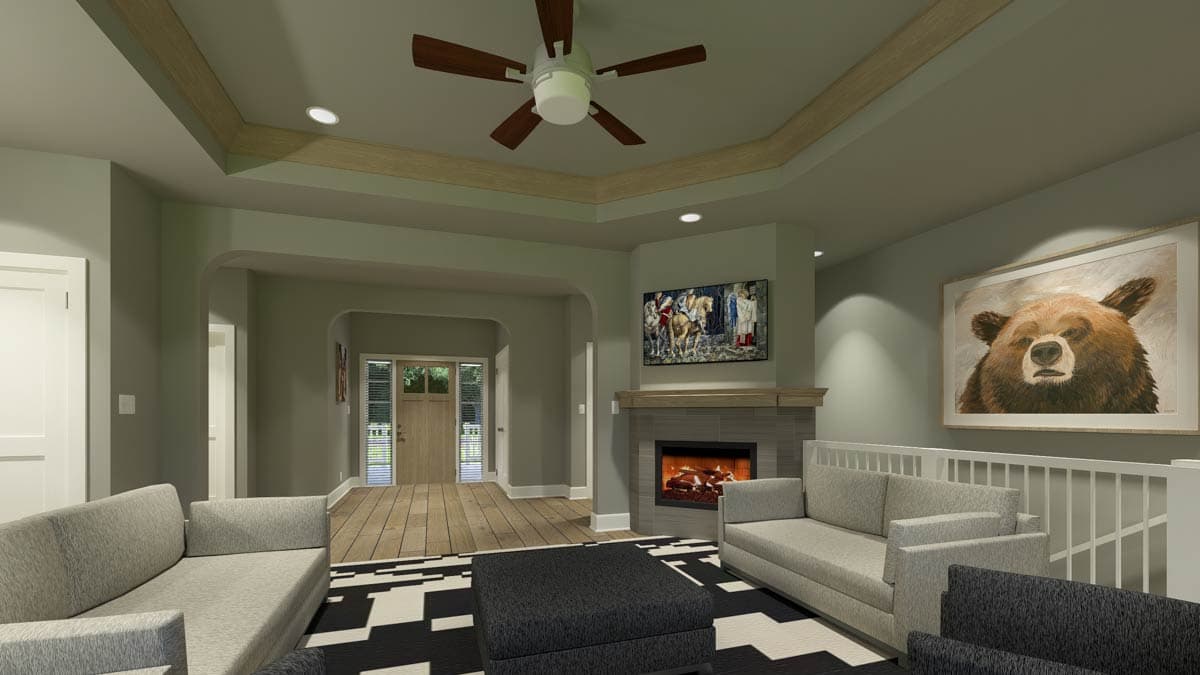 Cozy living room with a fireplace, a bear painting, and a black and white rug. A TV is above the fireplace, and the room has gray couches.