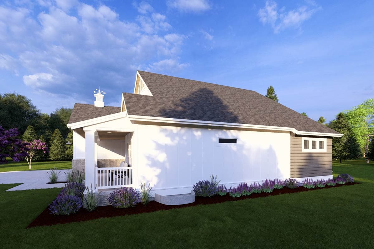 A modern, white house with a porch and gray roof is surrounded by landscaping and trees under a cloudy blue sky.