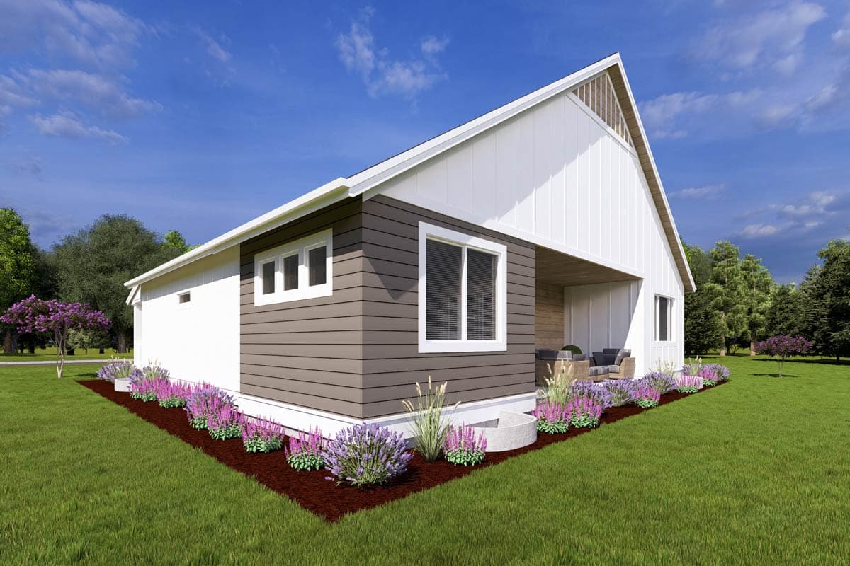 A modern one-story house with a white exterior, brown siding, and a covered patio. Purple flowers line the front of the house and manicured lawn.