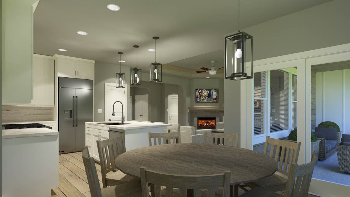 A modern kitchen and dining area featuring a large round table with chairs, an island with a sink, and a fireplace in the living area.
