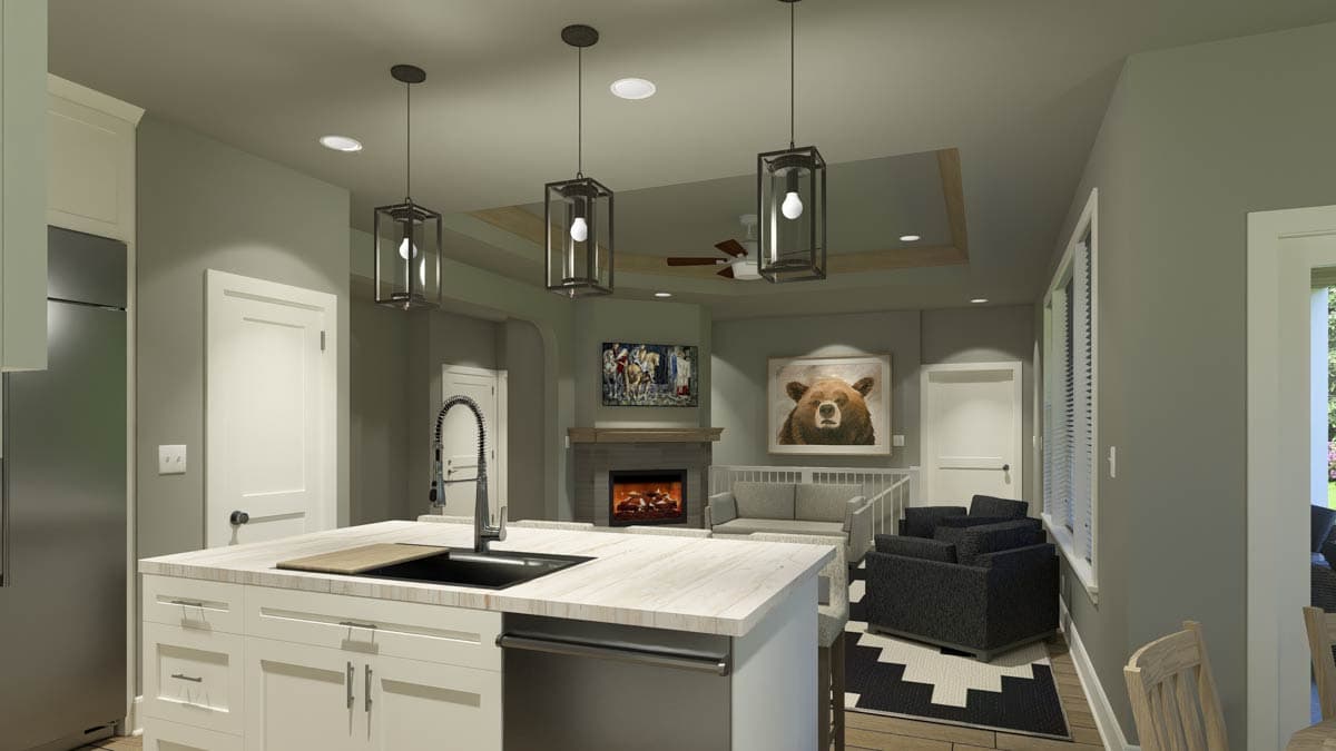 A modern kitchen island with pendant lights transitions to a living room with a fireplace and bear portrait, open concept design.