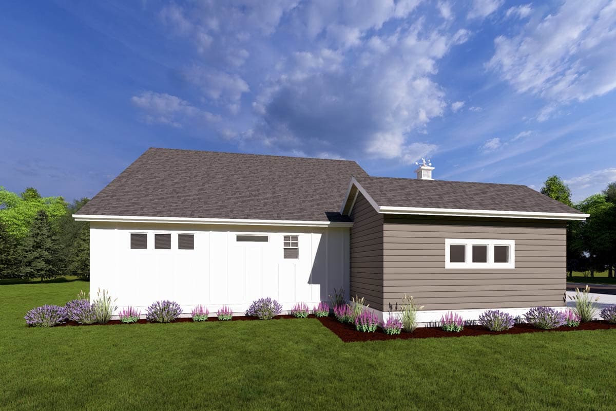 A modern white and brown house sits under a blue sky, surrounded by green grass and flowerbeds. Trees line the background of the image.