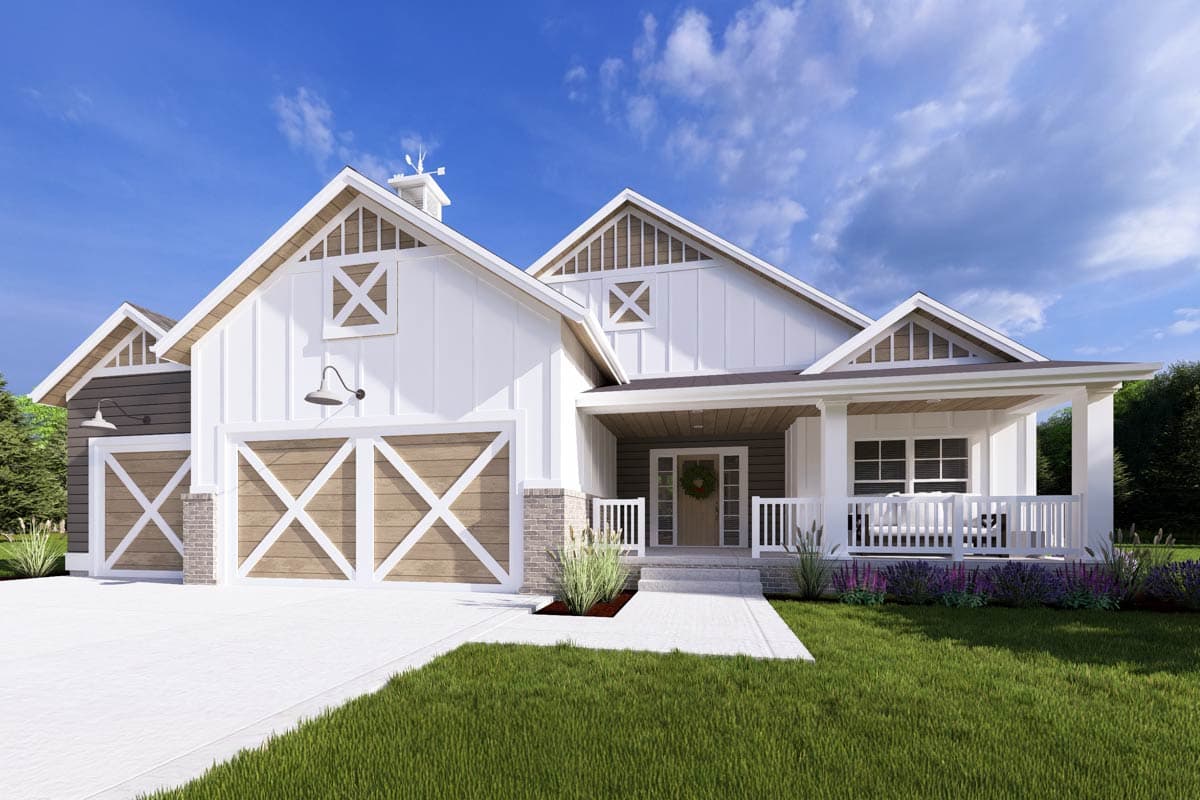 A modern farmhouse with white siding, wooden garage doors, and a front porch. A bright blue sky provides a backdrop, with a manicured lawn in front.