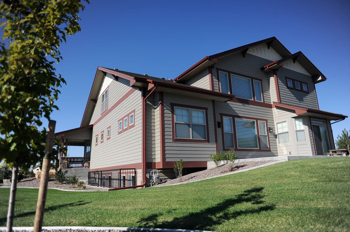 House plan exterior: Modern style, two-story with covered porch, multi-level gables, and horizontal siding.