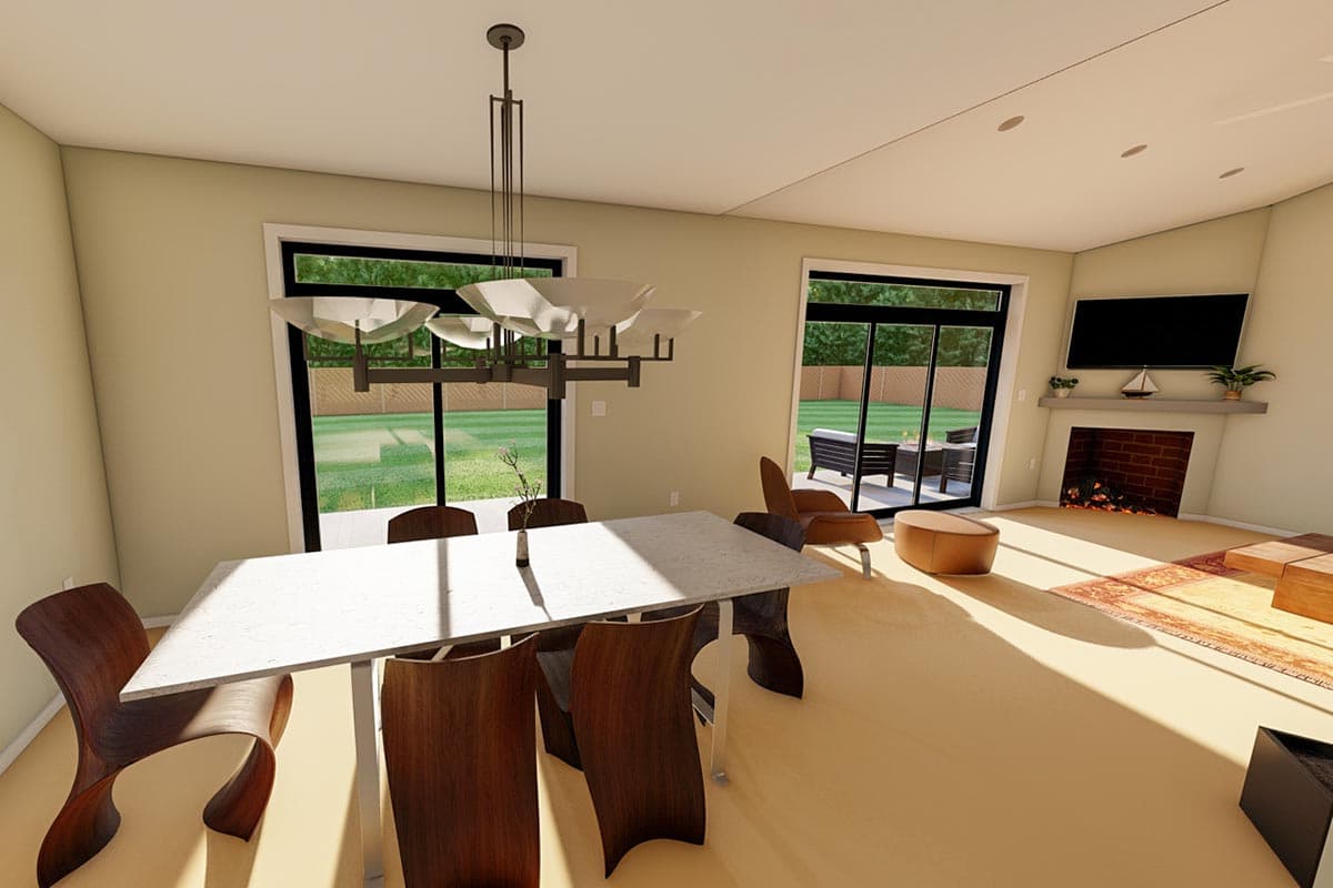 Dining area with a table and chairs, adjacent to a living area with a fireplace and television.