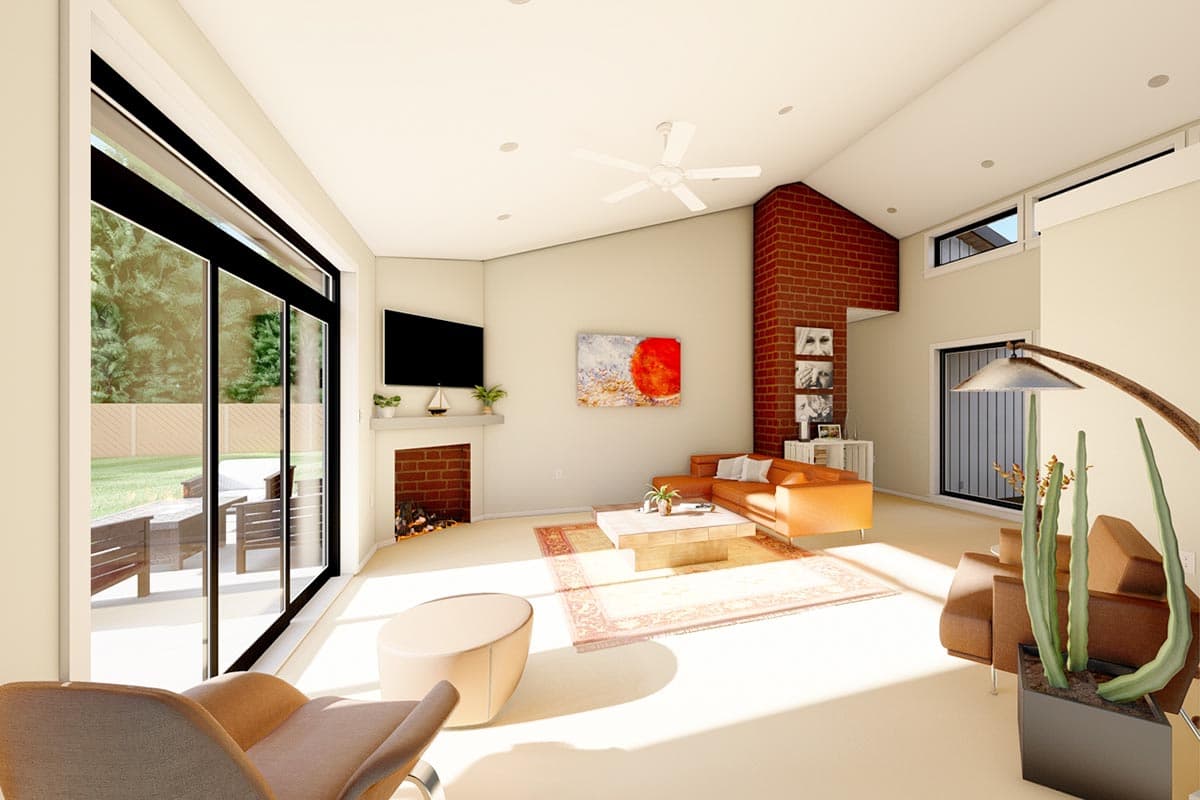 Living room with vaulted ceiling, fireplace, sectional sofa, and large sliding glass doors opening to patio.