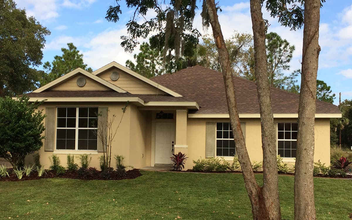 Ranch style house plan exterior with gabled front roof, covered entryway with columns, and multiple windows.