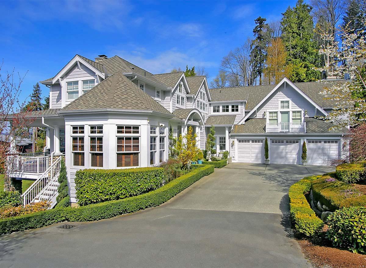 House plan exterior of a multi-story home with a prominent bay window, multiple gables, and a three-car garage.